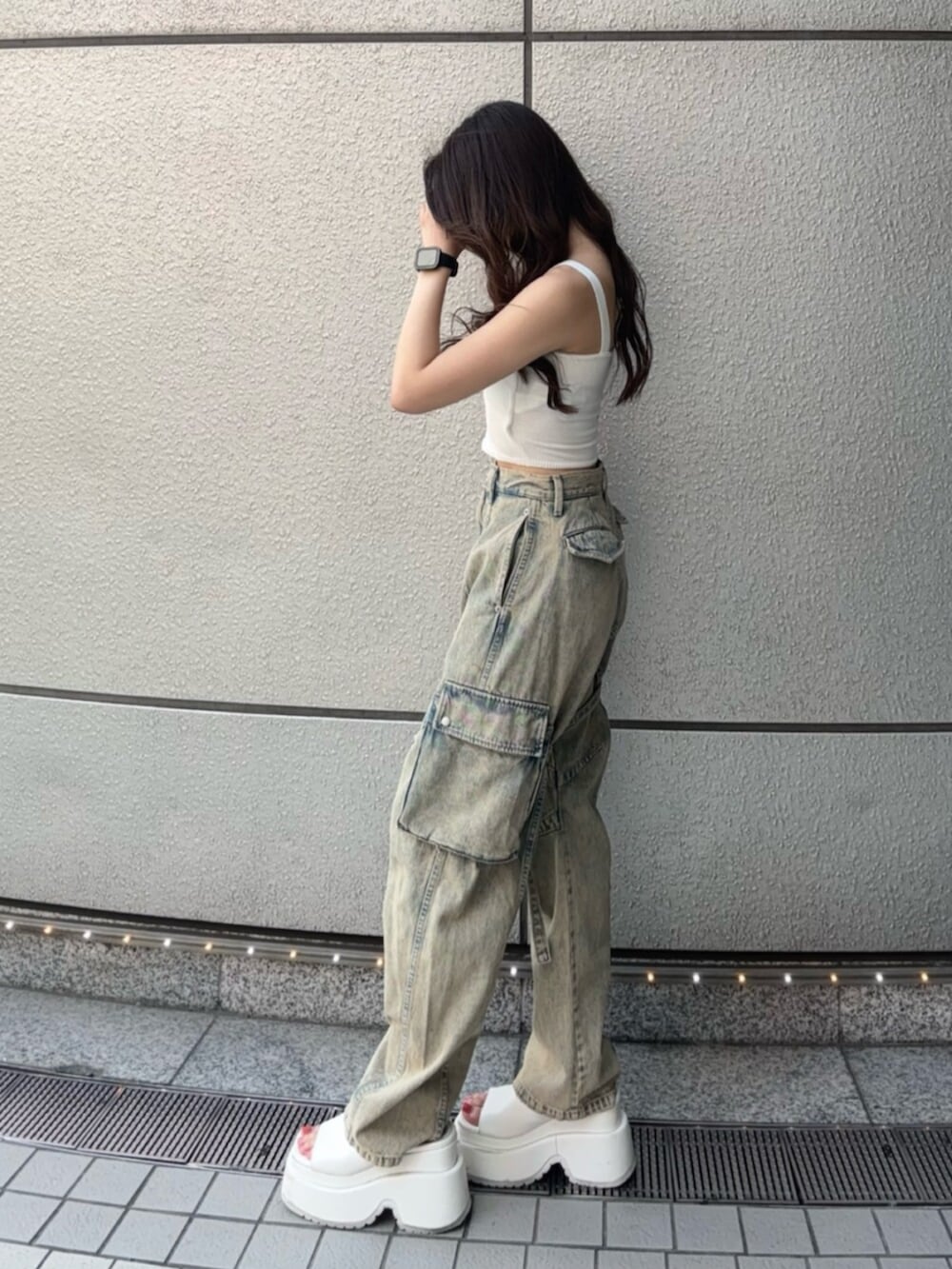 ホワイト系のサンダル、ホワイト系のキャミソール、ブルー系のデニムパンツを着用したレディースの夏コーディネートの2枚目の写真