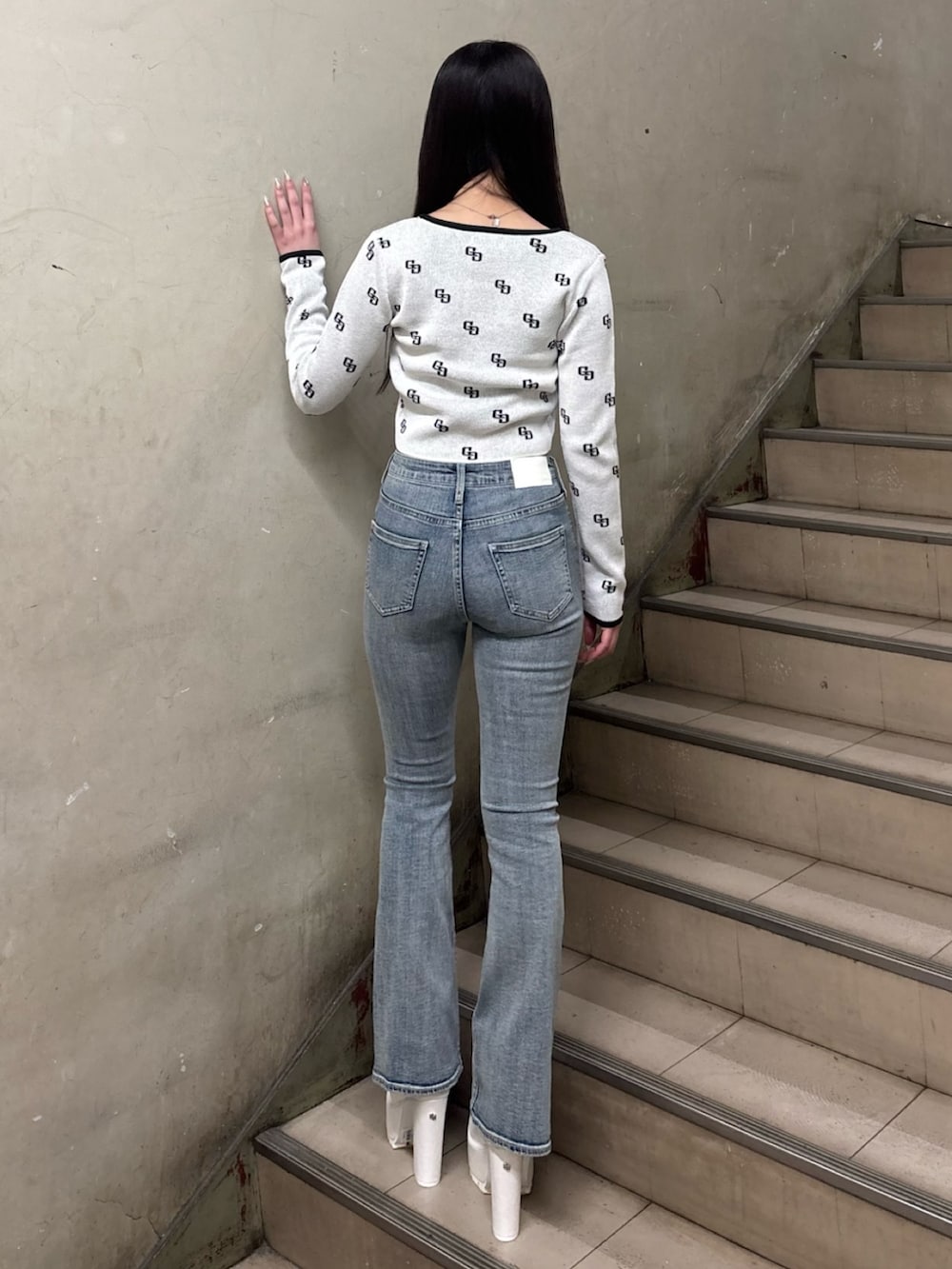 ホワイト系のニット/セーター、ブルー系のデニムパンツ、ホワイト系のブーツを着用したレディースの冬コーディネートの3枚目の写真