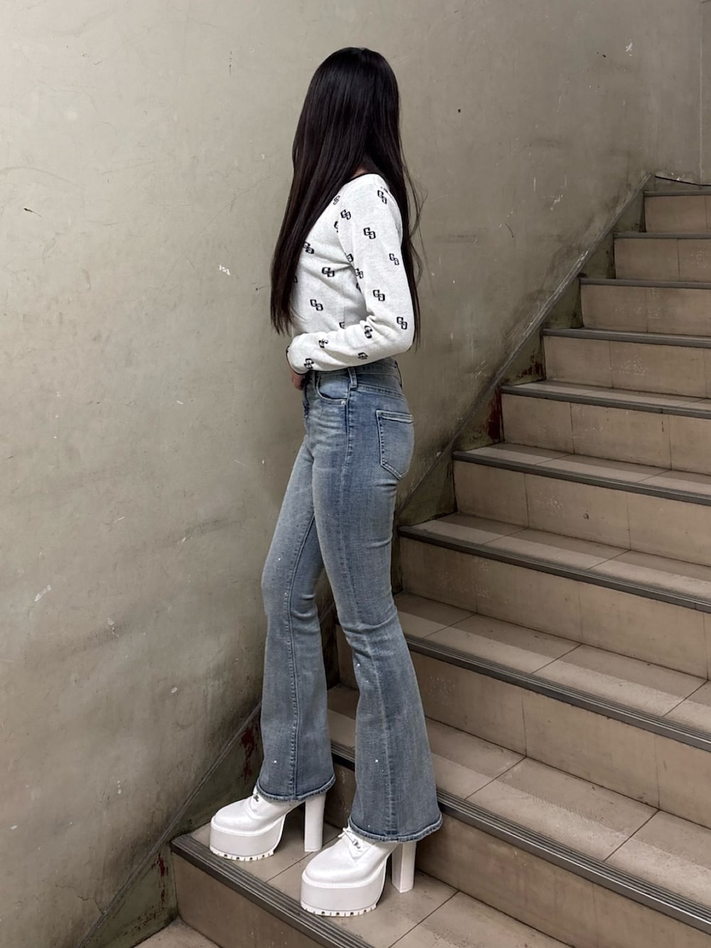 ホワイト系のニット/セーター、ブルー系のデニムパンツ、ホワイト系のブーツを着用したレディースの冬コーディネートの2枚目の写真