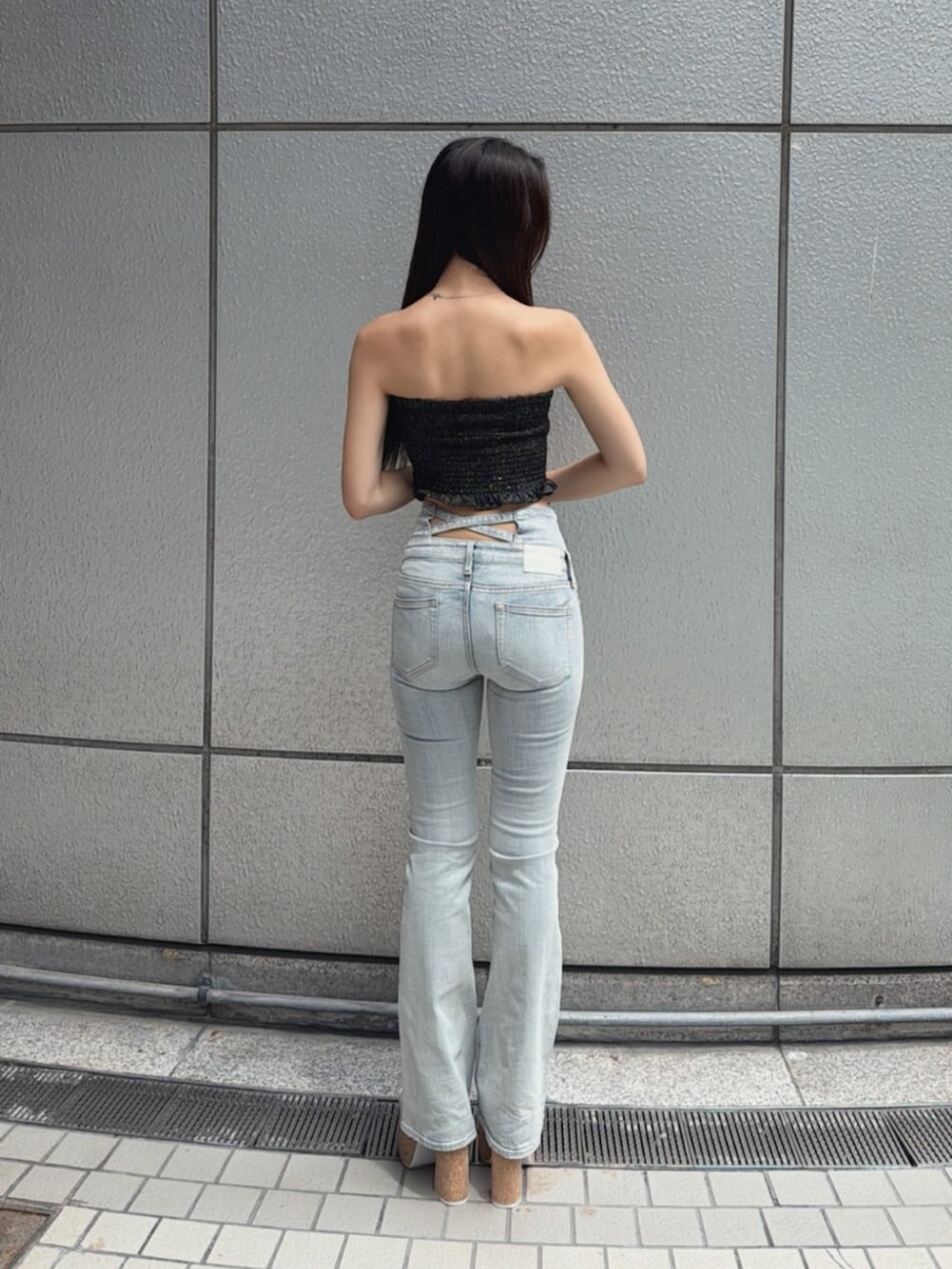 ホワイト系のサンダル、ブルー系のデニムパンツ、ブラック系のチューブトップを着用したレディースの夏コーディネートの3枚目の写真