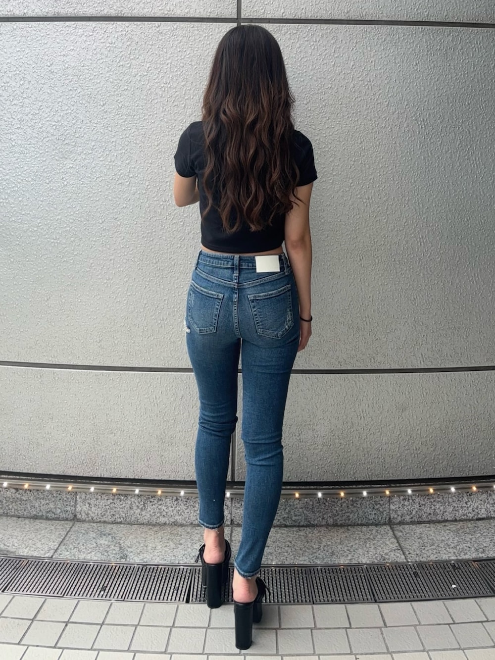 ブラック系のTシャツ/カットソー、ブルー系のデニムパンツ、ブラック系のサンダルを着用したレディースの夏コーディネートの3枚目の写真