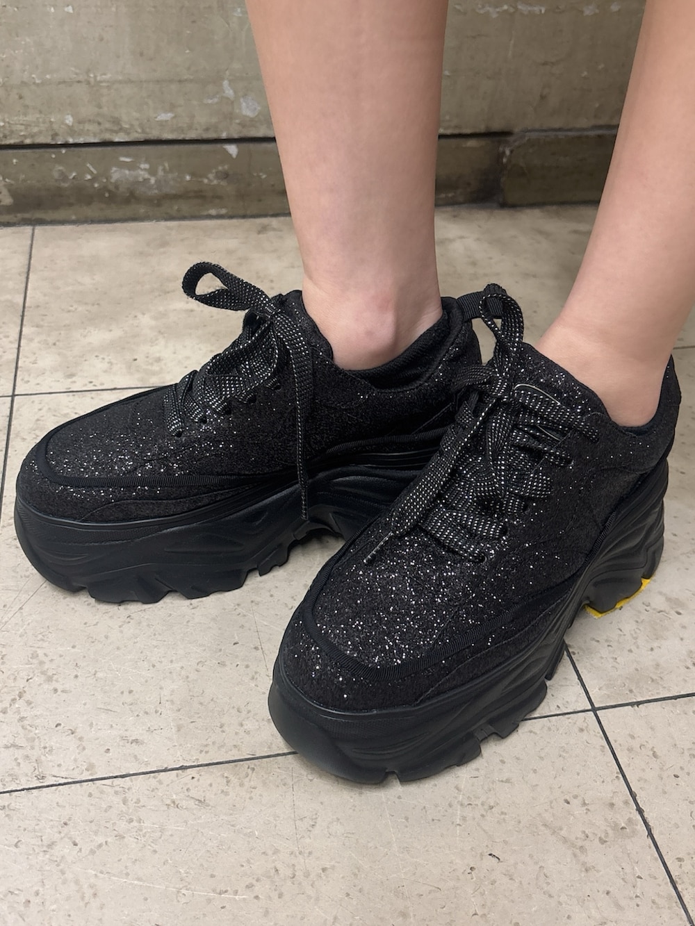 グレー系のTシャツ/カットソー、ブルー系のデニムスカート、ブラック系のスニーカーを着用したレディースの春コーディネートの4枚目の写真