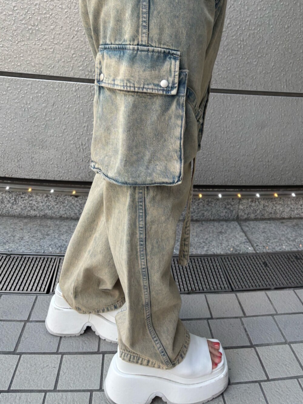 ホワイト系のサンダル、ホワイト系のキャミソール、ブルー系のデニムパンツを着用したレディースの夏コーディネートの4枚目の写真