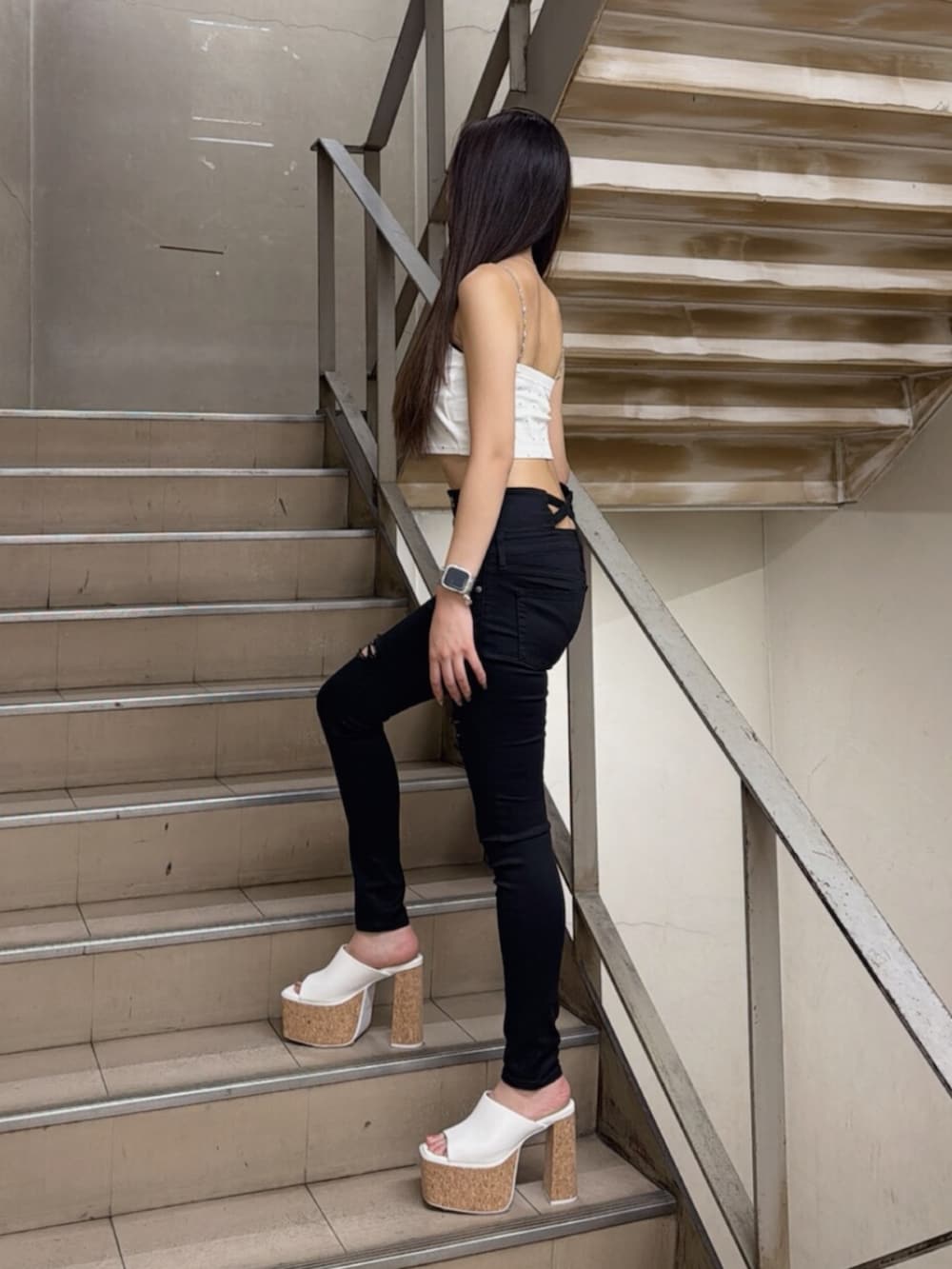 ホワイト系のサンダル、ホワイト系のキャミソール、ブラック系のデニムパンツを着用したレディースの夏コーディネートの2枚目の写真
