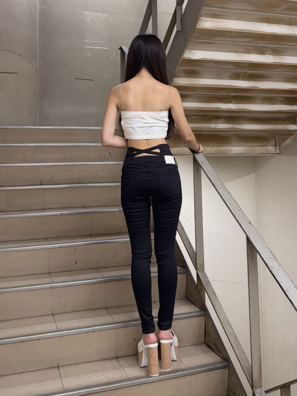 ホワイト系のサンダル、ホワイト系のキャミソール、ブラック系のデニムパンツを着用したレディースの夏コーディネートの3枚目の写真