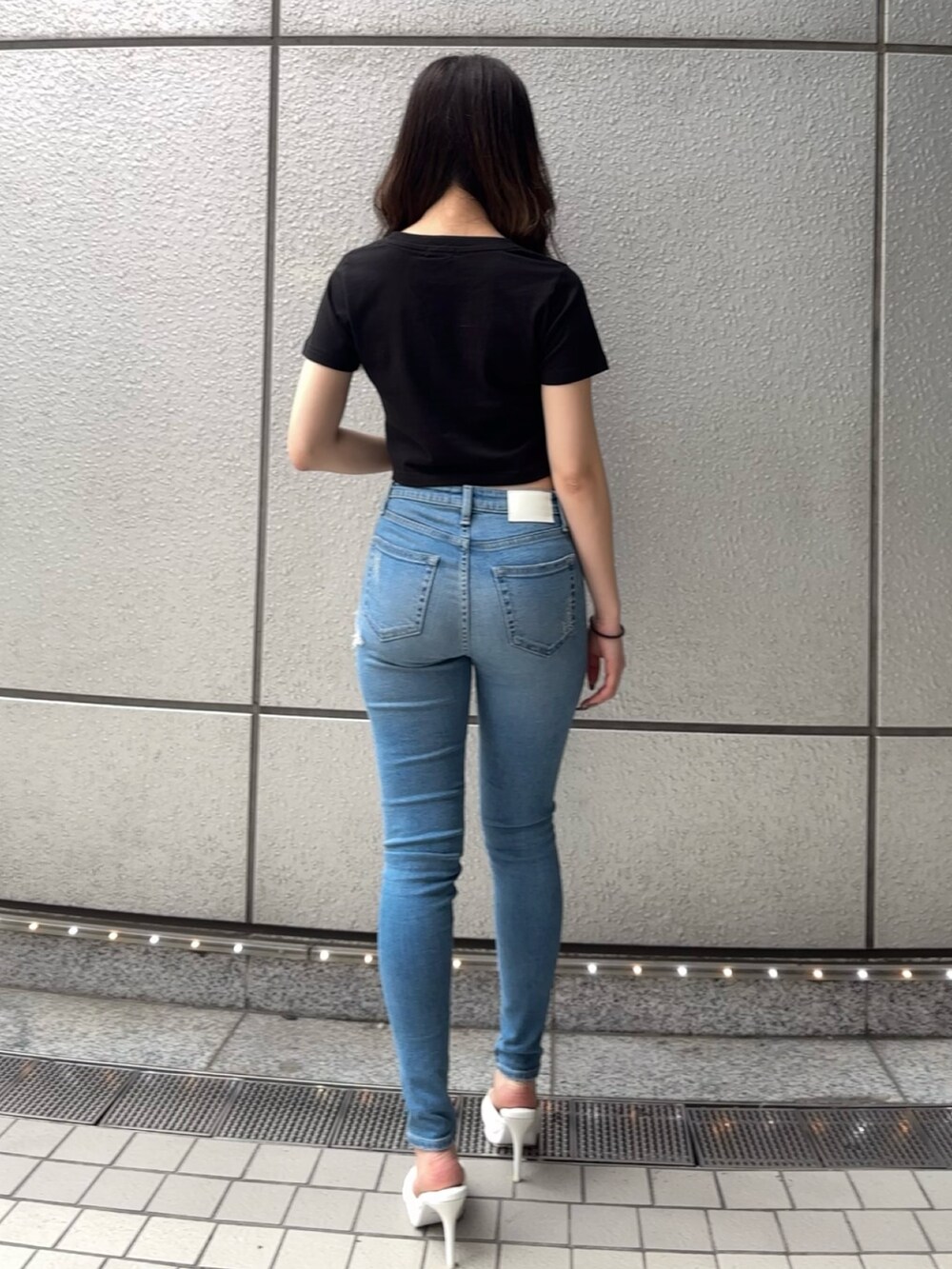 ブラック系のTシャツ/カットソー、ブルー系のデニムパンツ、ホワイト系のパンプスを着用したレディースの春コーディネートの3枚目の写真