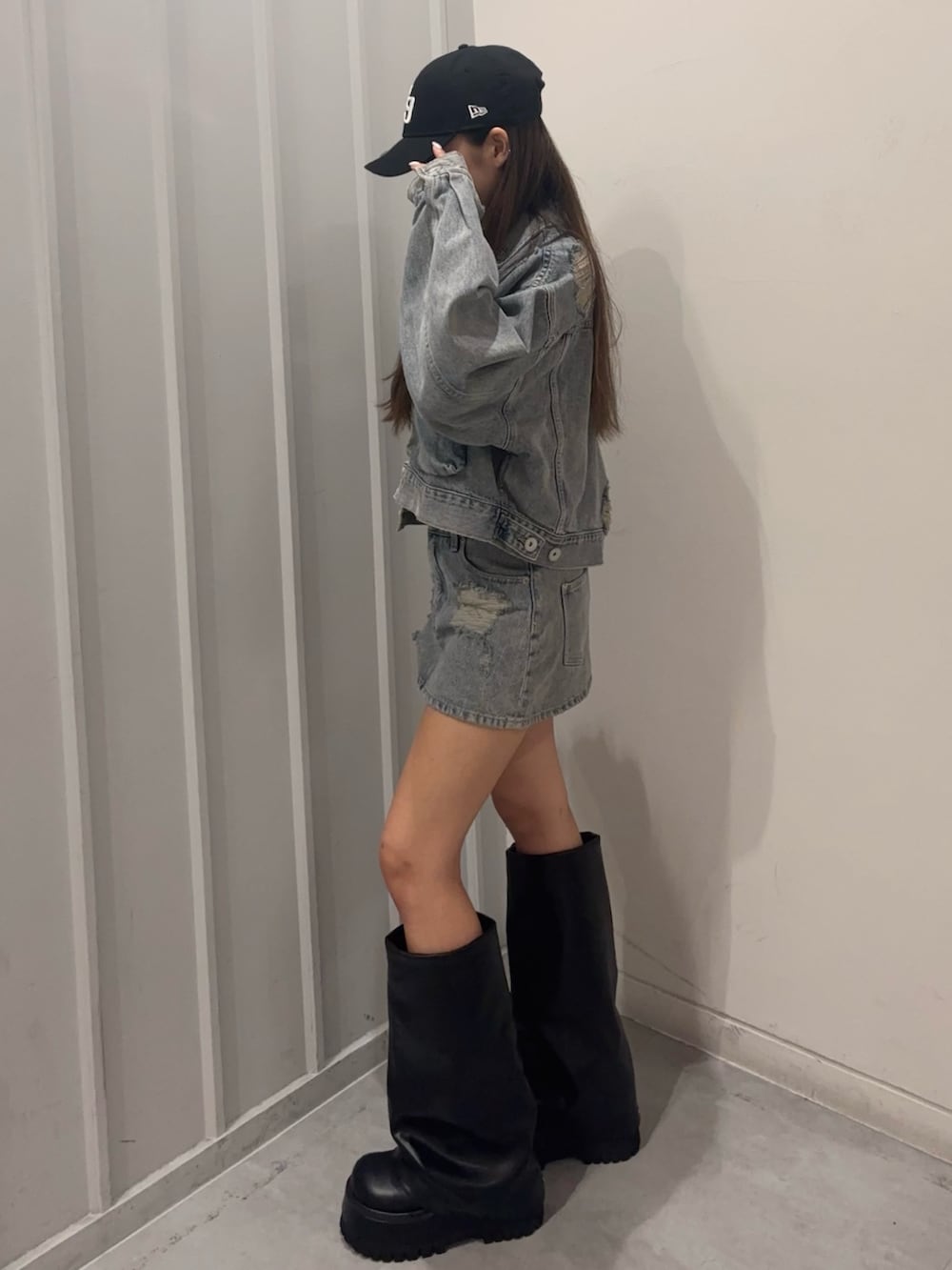 ブラック系のキャミソール、ブルー系のデニムスカート、ブルー系のデニムジャケットを着用したレディースの秋コーディネートの2枚目の写真