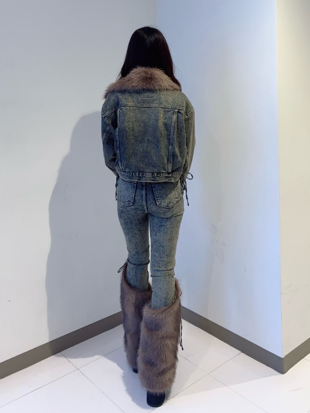 ブルー系のデニムジャケット、ブルー系のデニムパンツ、ブラック系のブーツを着用したレディースの秋コーディネートの3枚目の写真