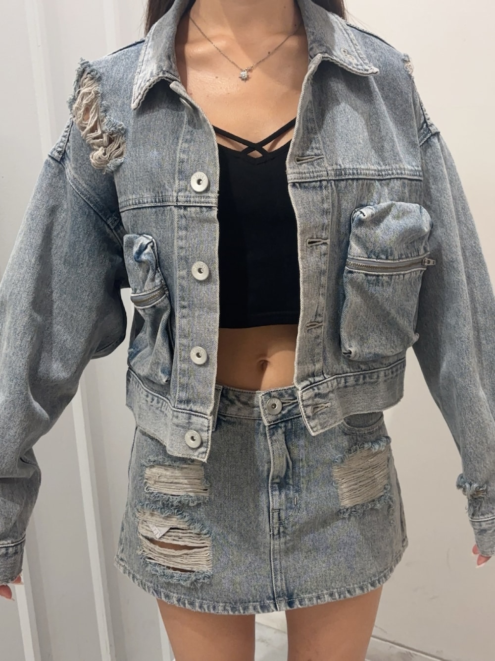 ブラック系のキャミソール、ブルー系のデニムスカート、ブルー系のデニムジャケットを着用したレディースの秋コーディネートの4枚目の写真