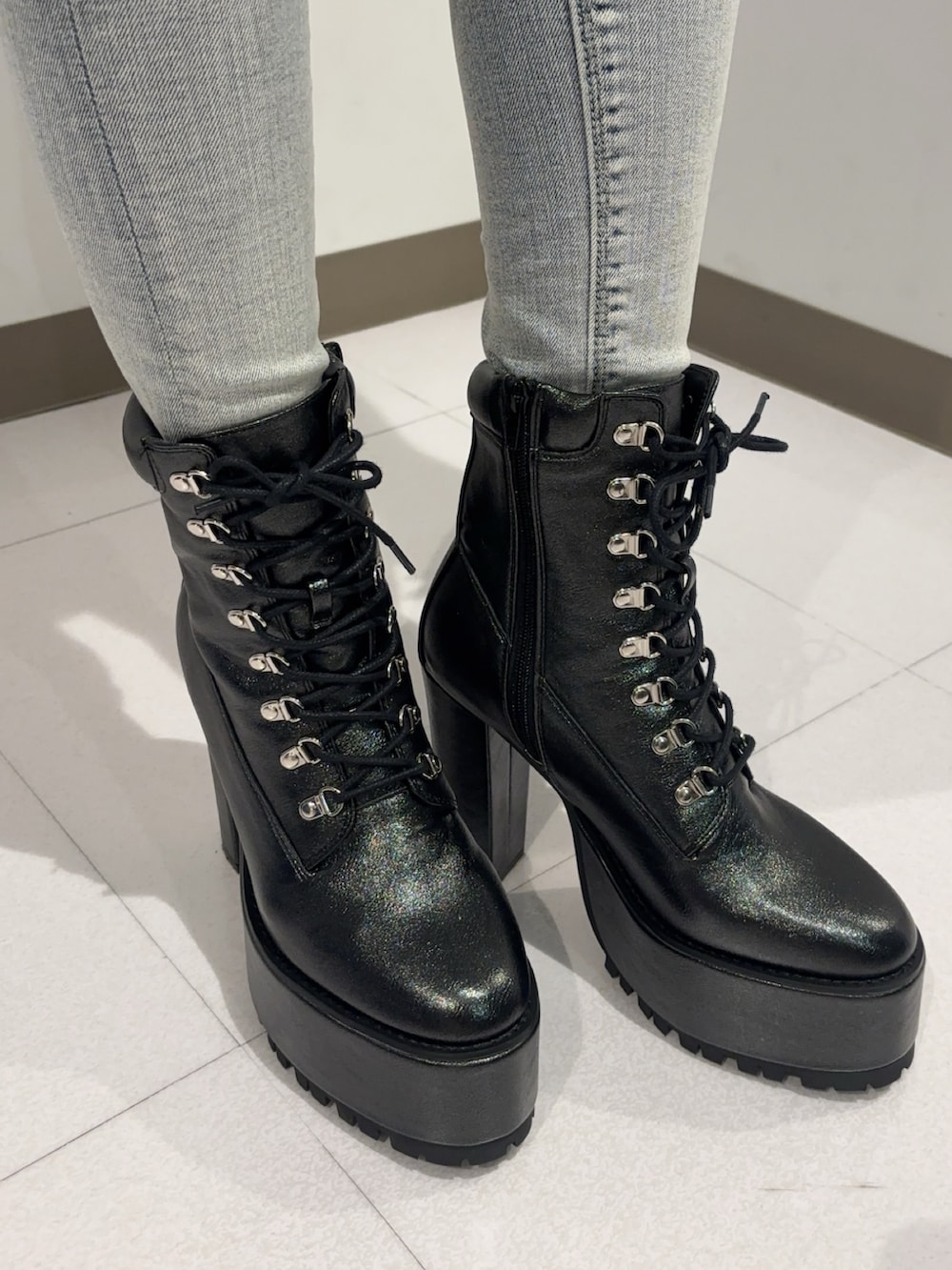 ブラック系のニット/セーター、ブルー系のデニムパンツ、ブラック系のブーツを着用したレディースの冬コーディネートの4枚目の写真