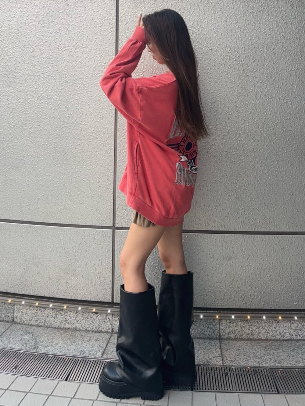 レッド系のスウェット、グリーン系のその他パンツ、ブラック系のブーツを着用したレディースの夏コーディネートの2枚目の写真