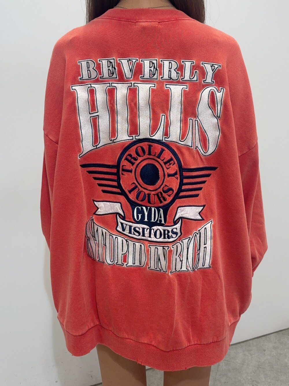 レッド系のスウェット、グリーン系のその他パンツ、ブラック系のブーツを着用したレディースの夏コーディネートの4枚目の写真