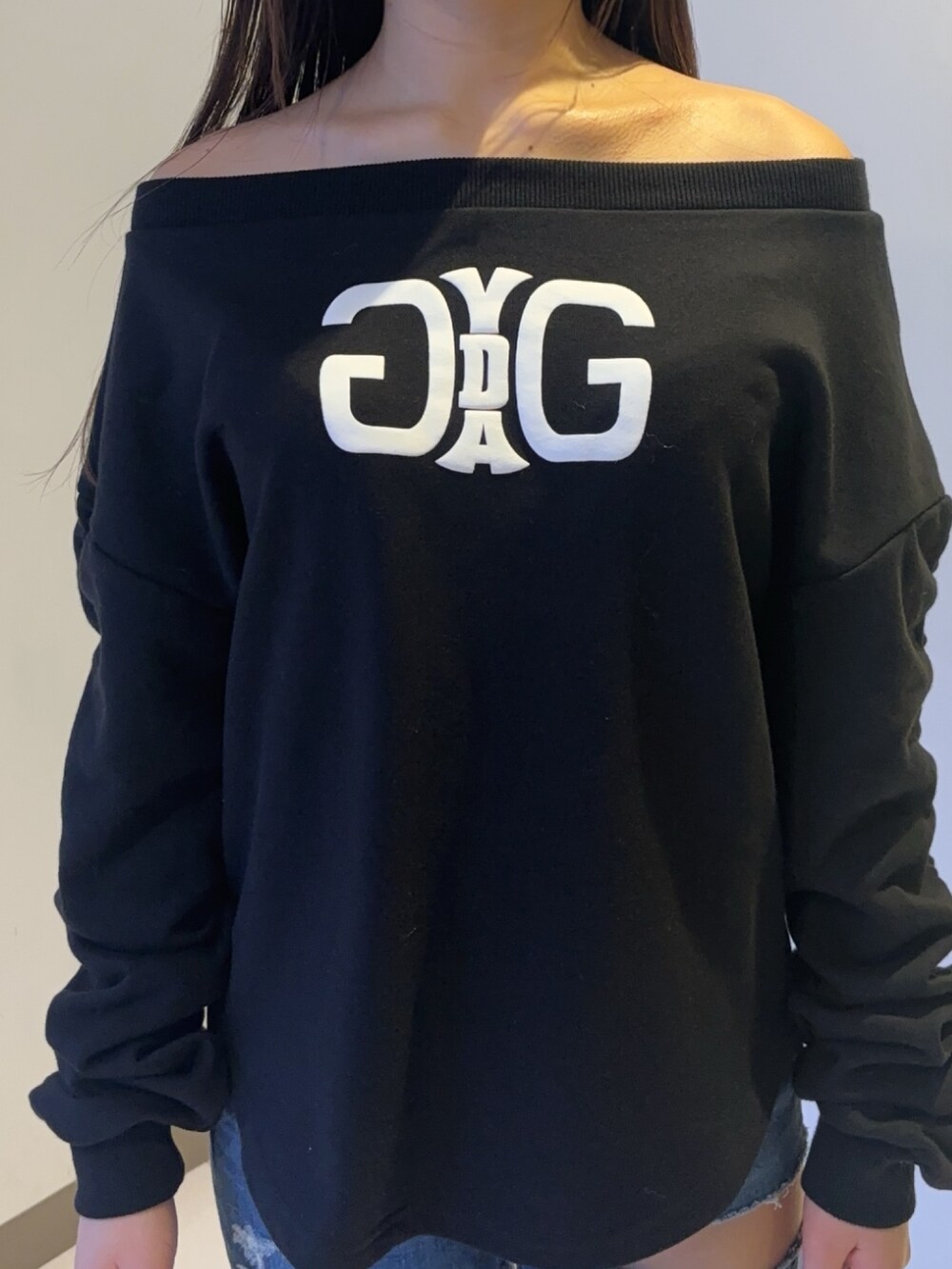 ブラック系のスウェット、ブルー系のデニムパンツ、ブラック系のブーツを着用したレディースの秋コーディネートの4枚目の写真