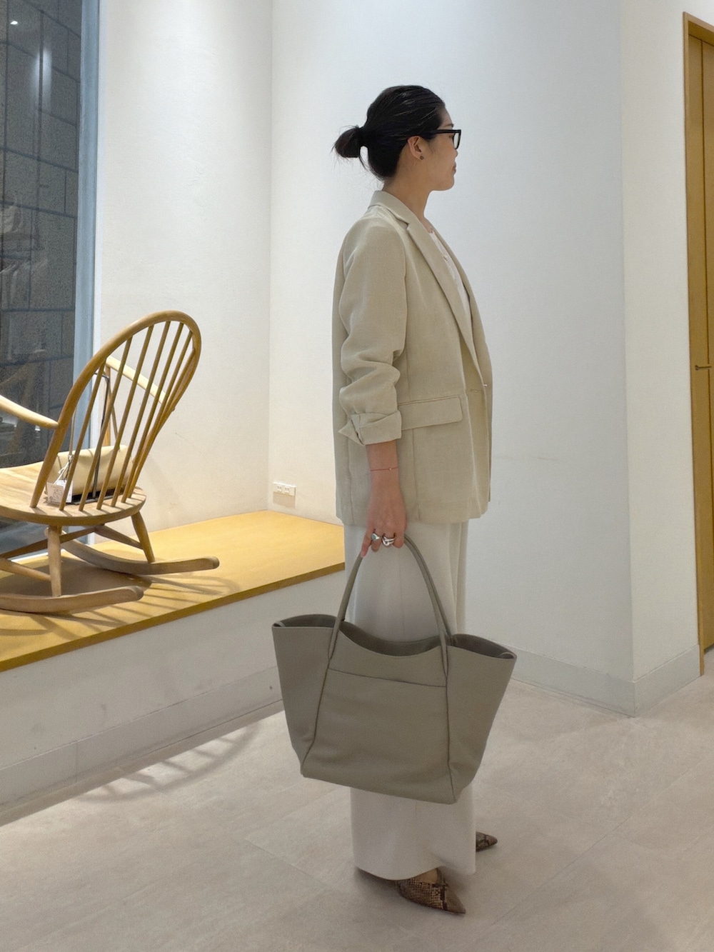 ブラウン系のパンプス、ベージュ系のトートバッグ、ベージュ系のテーラードジャケットを着用したレディースの春コーディネートの6枚目の写真