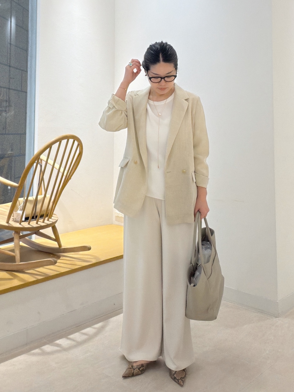 ブラウン系のパンプス、ベージュ系のトートバッグ、ベージュ系のテーラードジャケットを着用したレディースの春コーディネートの2枚目の写真
