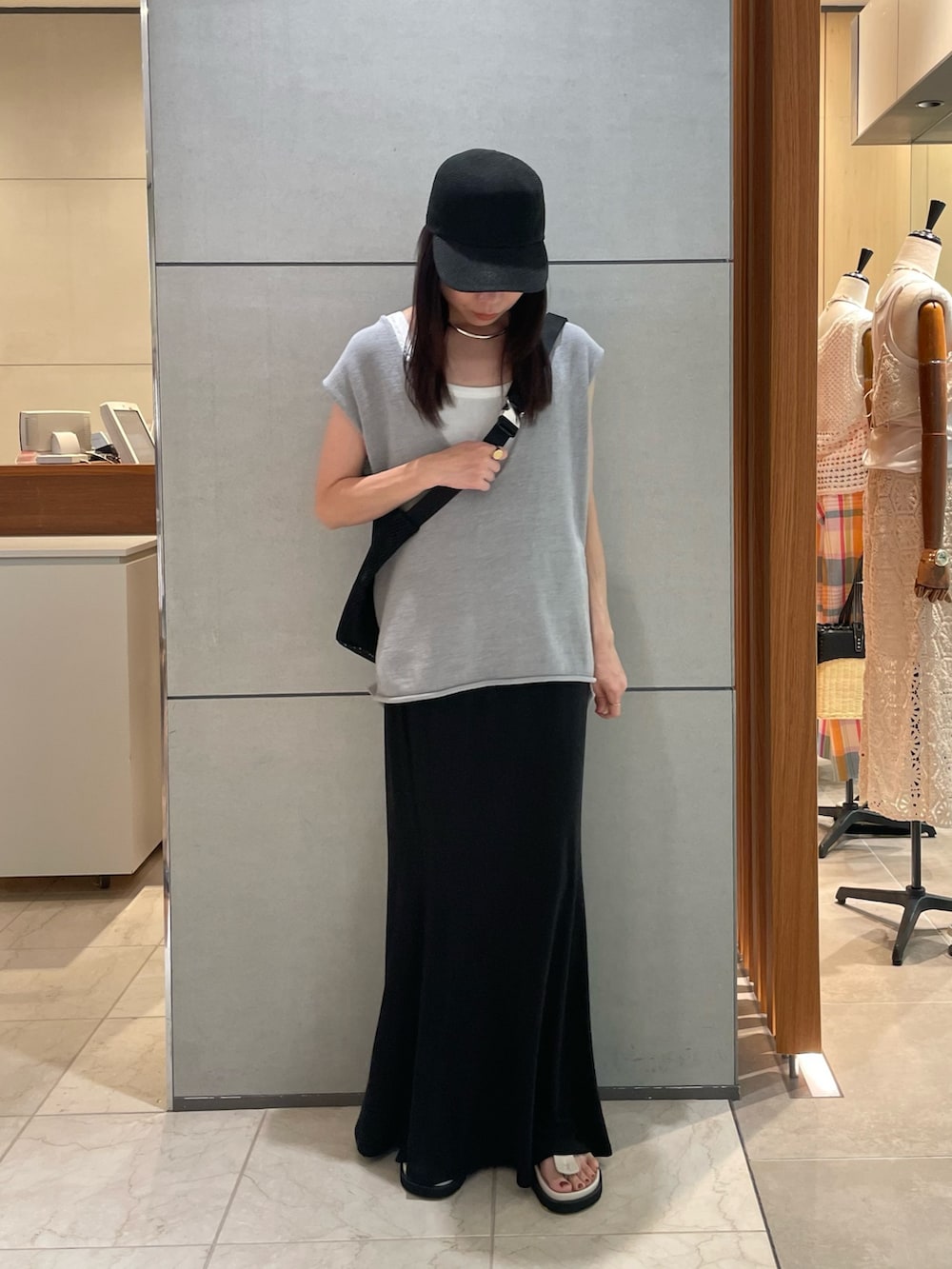 ブルー系のニット/セーター、ブラック系のスカート、ホワイト系のサンダルを着用したレディースの夏コーディネートの2枚目の写真