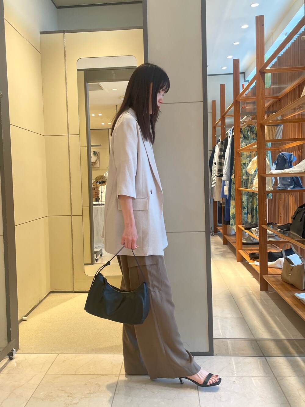 ブラウン系のその他パンツ、ブラック系のサンダル、ゴールド系のトートバッグを着用したレディースの夏コーディネートの3枚目の写真