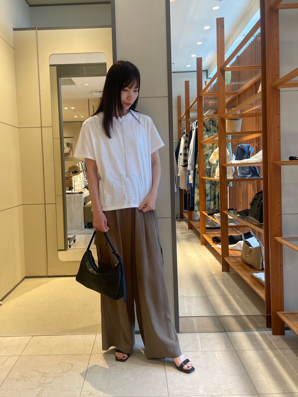 ブラウン系のその他パンツ、ブラック系のサンダル、ゴールド系のトートバッグを着用したレディースの夏コーディネートの5枚目の写真