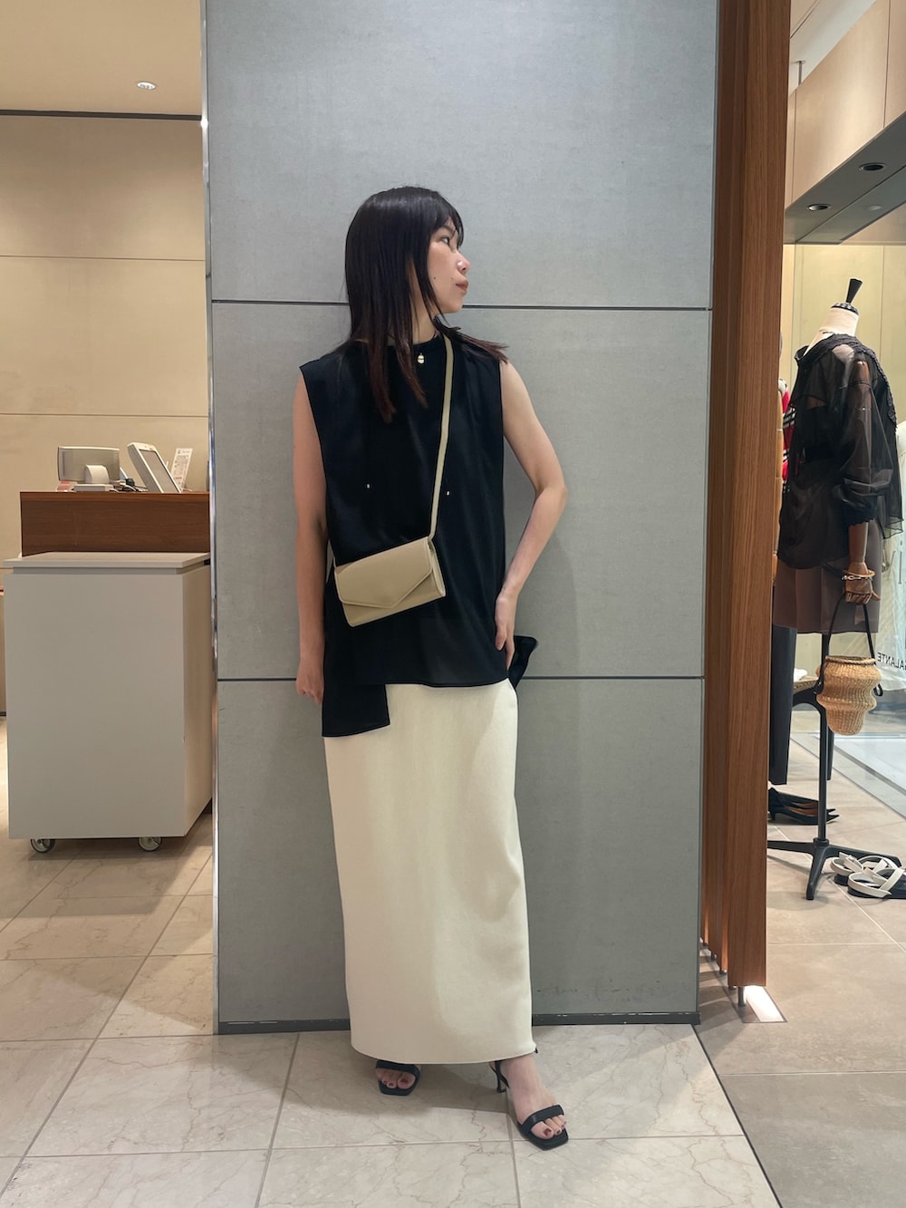 グリーン系のTシャツ/カットソー、ベージュ系のスカート、ブラック系のサンダルを着用したレディースの夏コーディネートの2枚目の写真