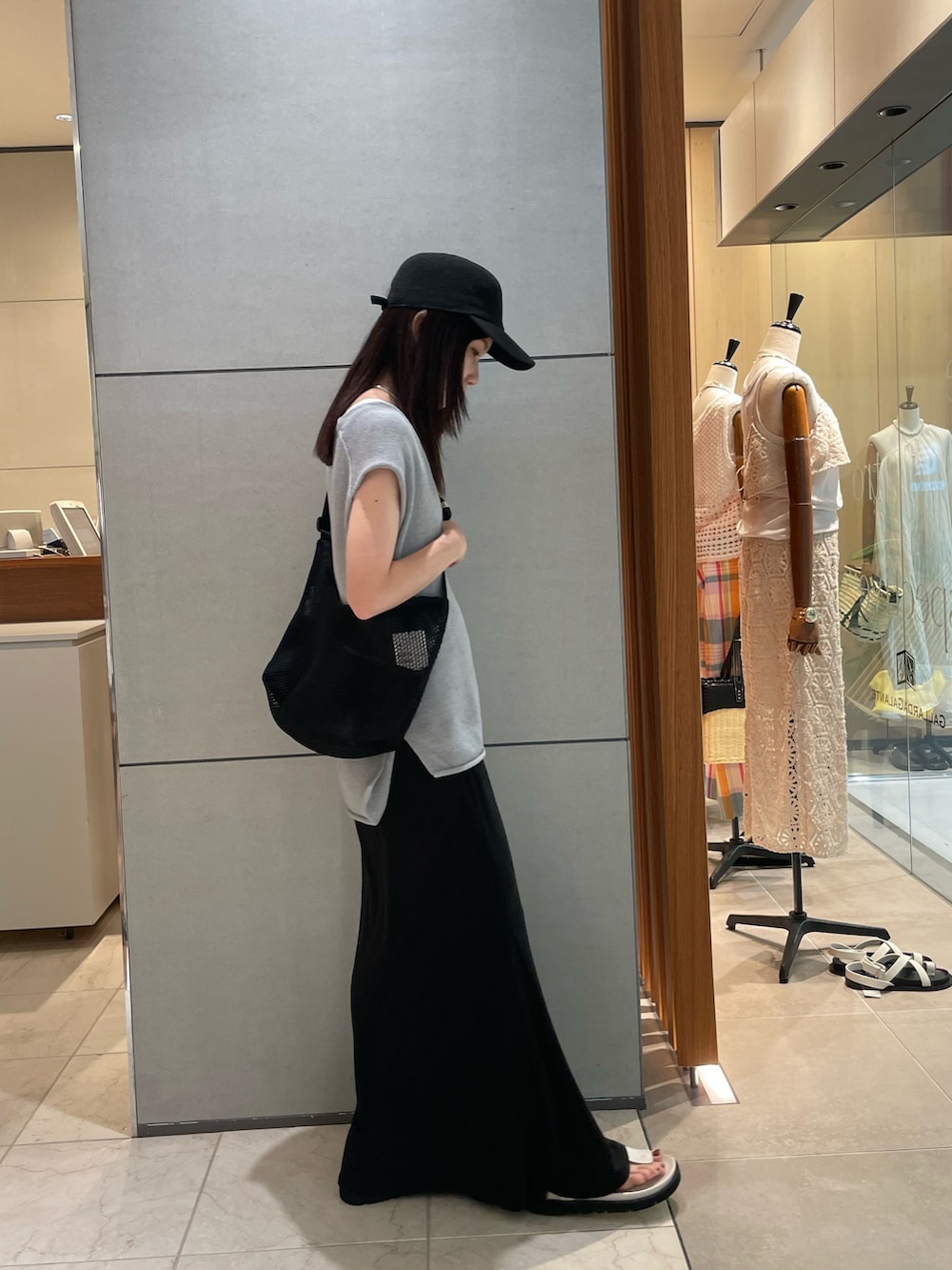 ブルー系のニット/セーター、ブラック系のスカート、ホワイト系のサンダルを着用したレディースの夏コーディネートの3枚目の写真