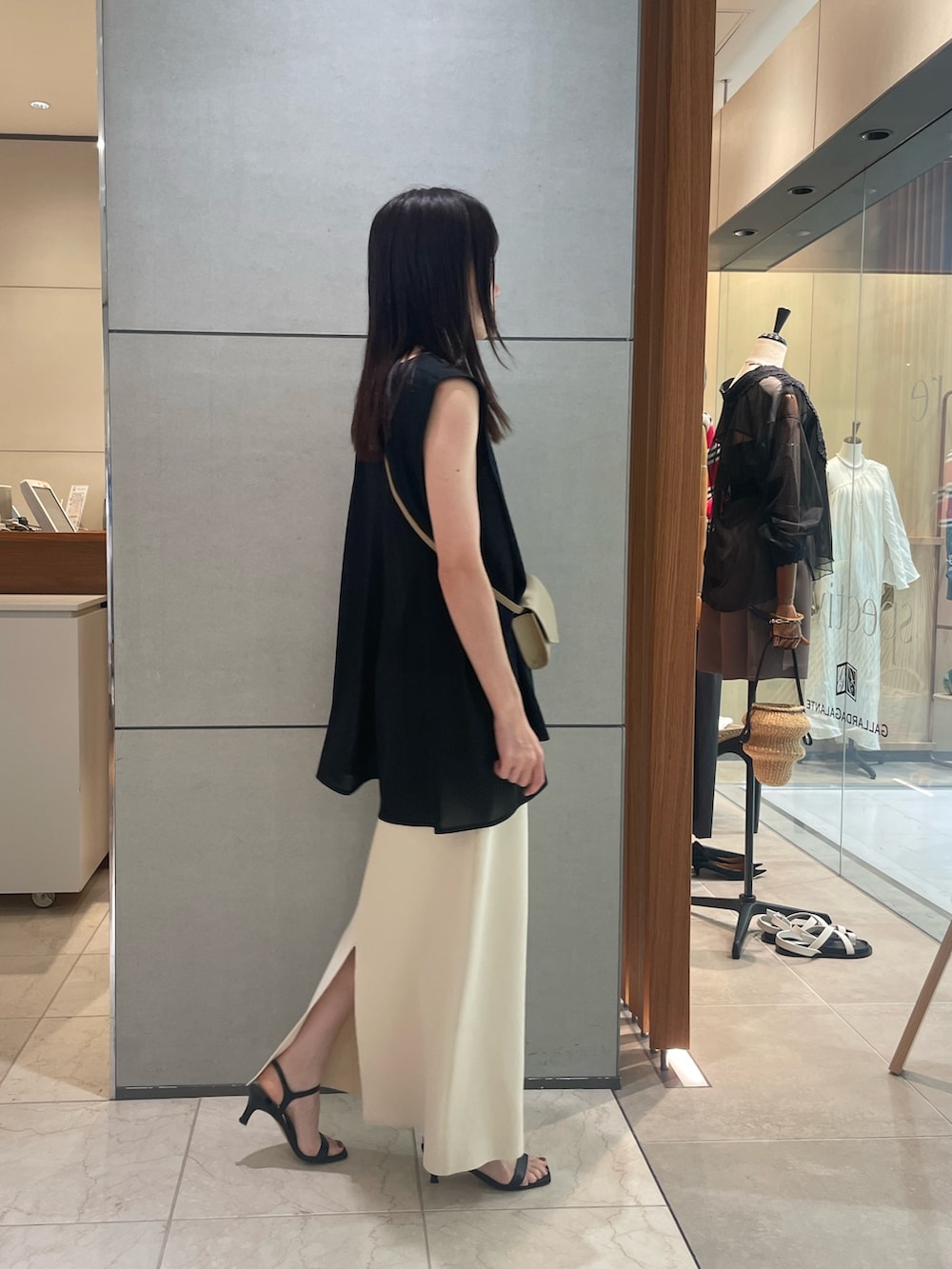 グリーン系のTシャツ/カットソー、ベージュ系のスカート、ブラック系のサンダルを着用したレディースの夏コーディネートの3枚目の写真