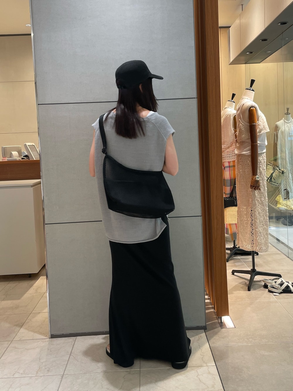 ブルー系のニット/セーター、ブラック系のスカート、ホワイト系のサンダルを着用したレディースの夏コーディネートの4枚目の写真