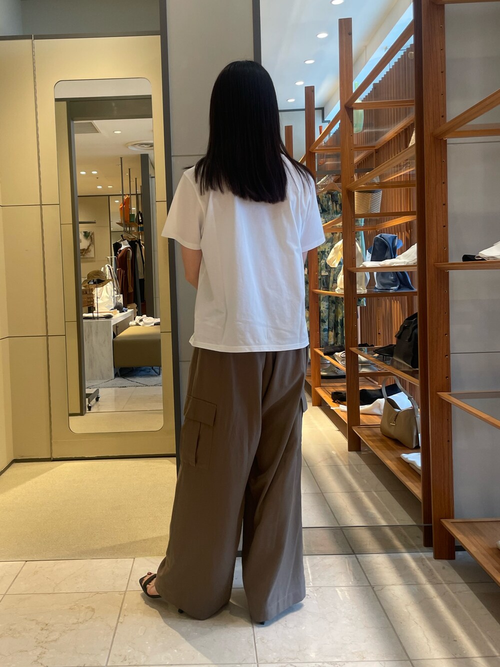 ブラウン系のその他パンツ、ブラック系のサンダル、ゴールド系のトートバッグを着用したレディースの夏コーディネートの7枚目の写真