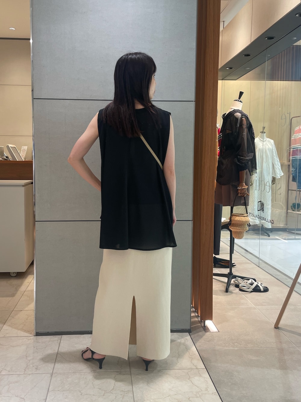 グリーン系のTシャツ/カットソー、ベージュ系のスカート、ブラック系のサンダルを着用したレディースの夏コーディネートの4枚目の写真