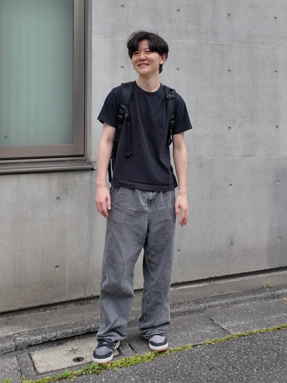 ブラック系のスニーカー、ブラック系のバックパック/リュック、ブラック系のトップスを着用したメンズの春コーディネートの2枚目の写真