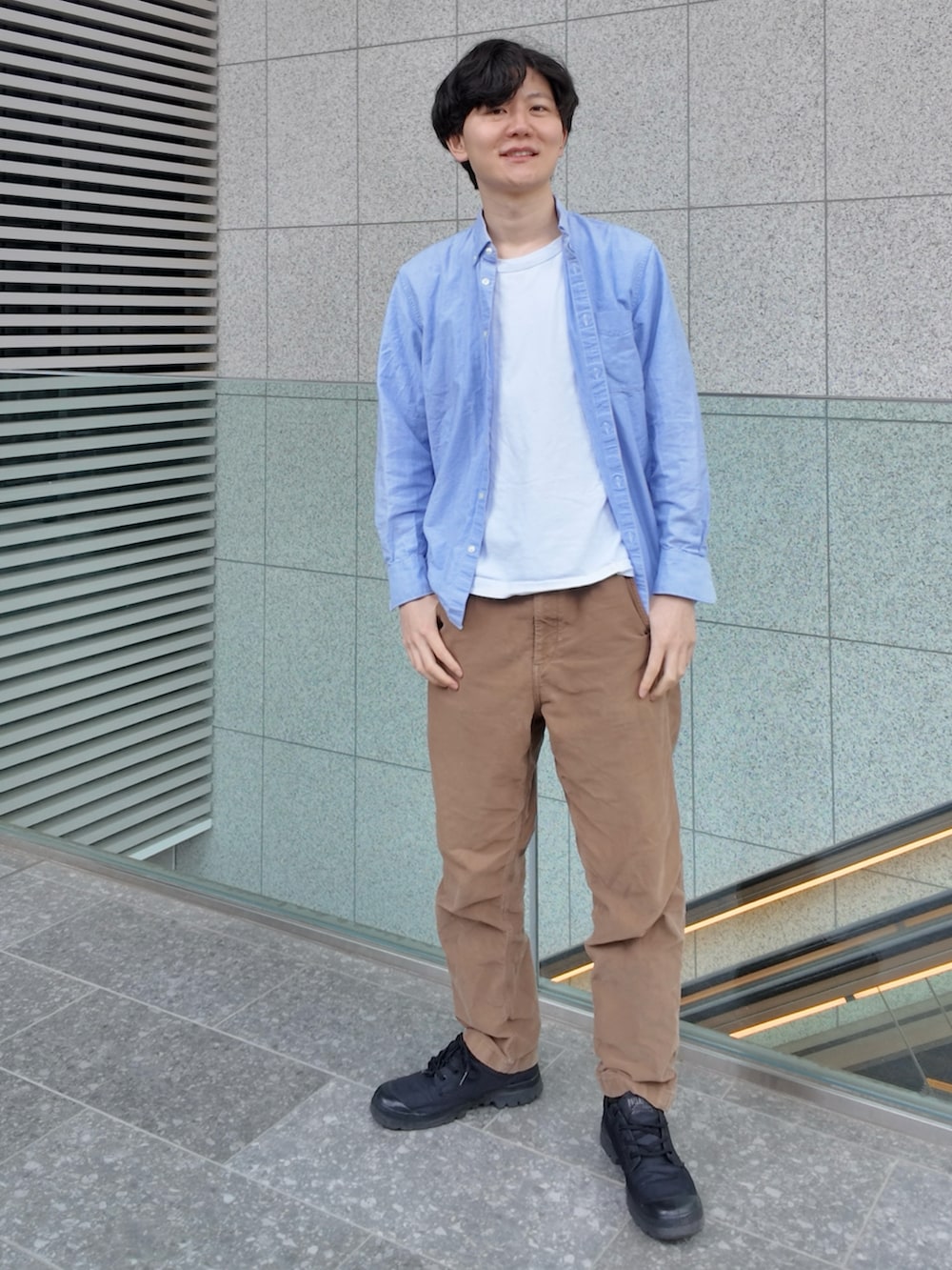 ブルー系のシャツ/ブラウス、ブラウン系のパンツ、ブラック系のスニーカーを着用したメンズの春コーディネートの3枚目の写真