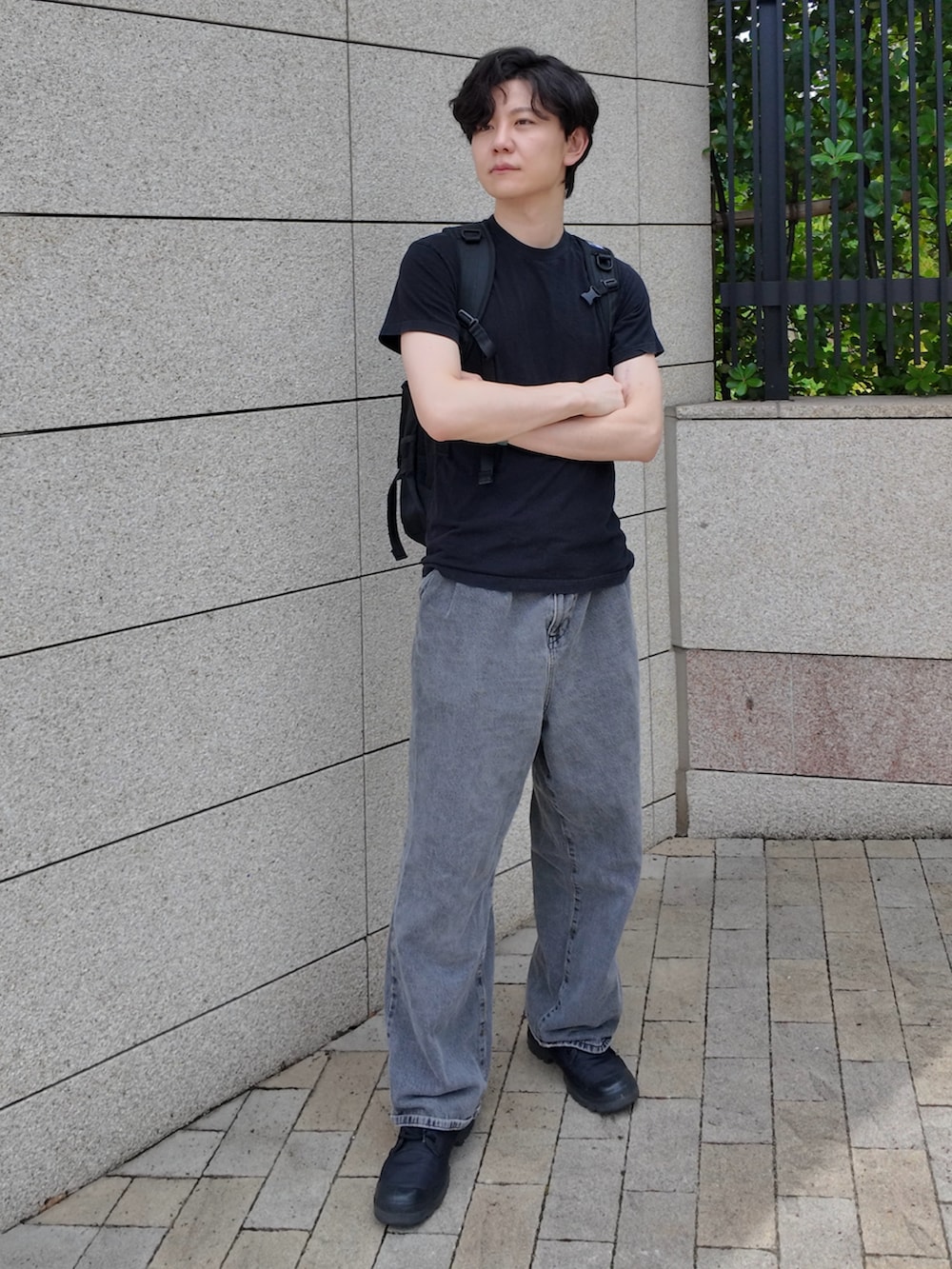 ブラック系のバックパック/リュック、ブラック系のトップス、ブラック系のスニーカーを着用したメンズの夏コーディネートの2枚目の写真