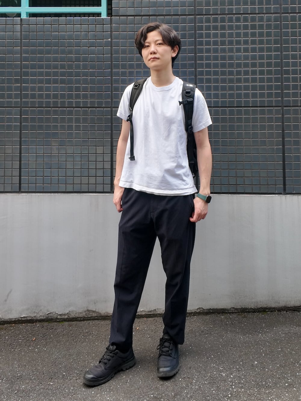 ブラック系のバックパック/リュック、ホワイト系のTシャツ/カットソー、ブラック系のパンツを着用したメンズの夏コーディネートの2枚目の写真