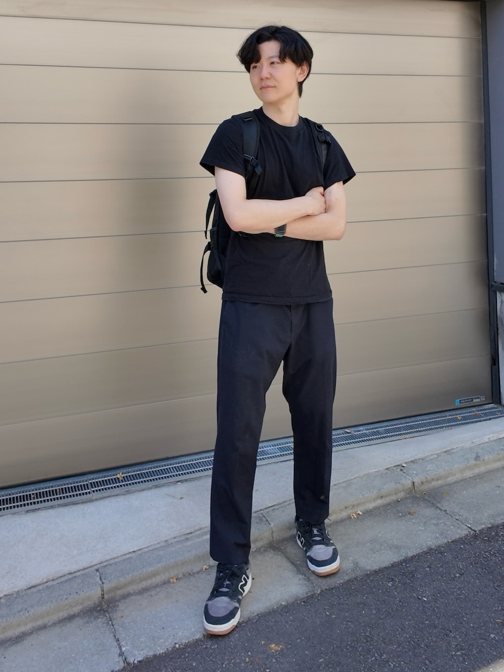 ブラック系のスニーカー、ブラック系のパンツ、ブラック系のバックパック/リュックを着用したメンズの春コーディネートの2枚目の写真