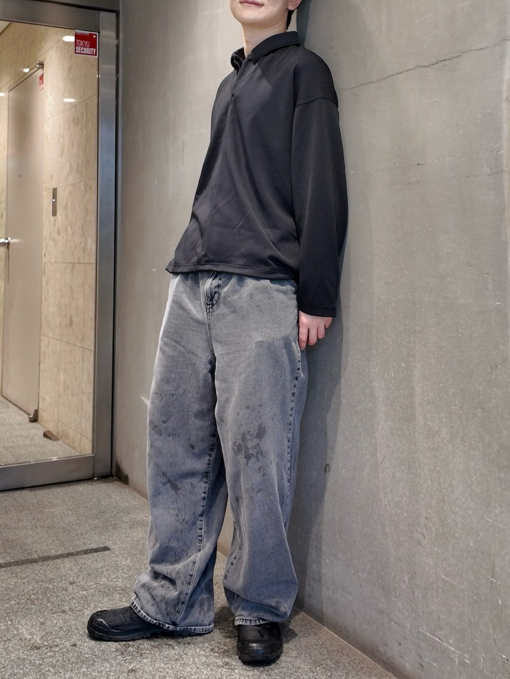 ブラック系のTシャツ/カットソー、グレー系のデニムパンツ、ブラック系のスニーカーを着用したメンズの秋コーディネートの2枚目の写真