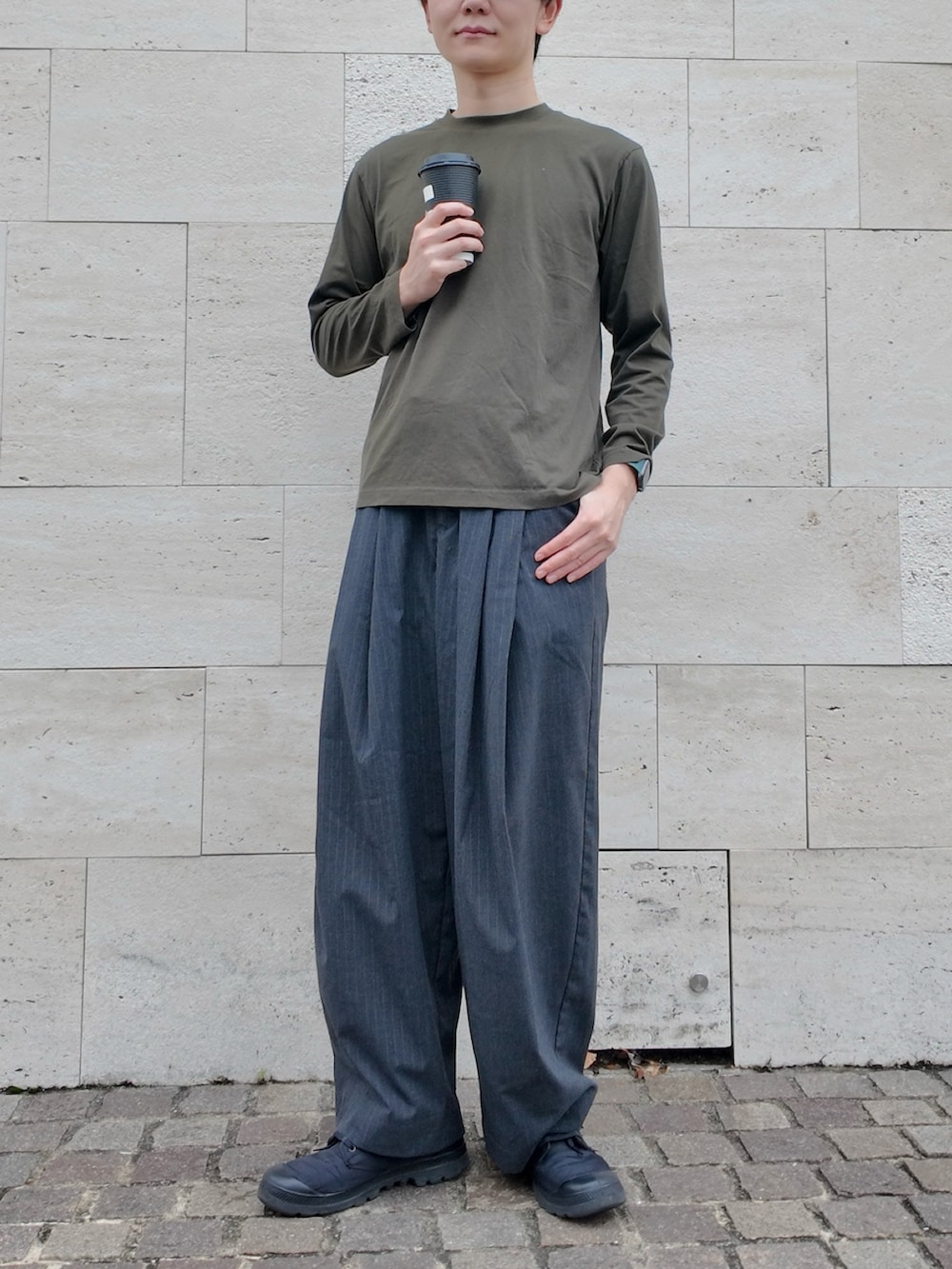その他のスラックス、グリーン系のTシャツ/カットソー、ブラック系のスニーカーを着用したメンズの秋コーディネートの2枚目の写真