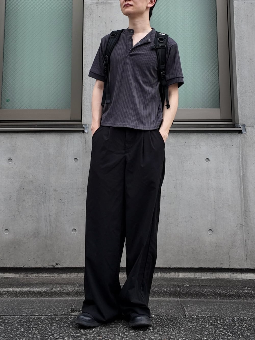 グレー系のTシャツ/カットソー、ブラック系のスラックス、ブラック系のスニーカーを着用したメンズの秋コーディネートの2枚目の写真