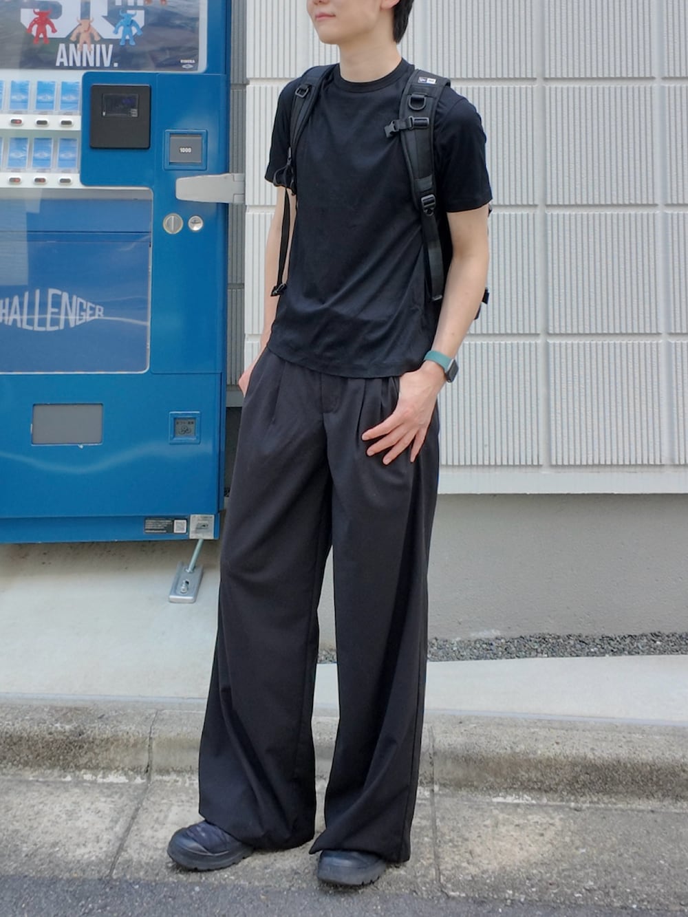 ブラック系のスラックス、ブラック系のTシャツ/カットソー、ブラック系のバックパック/リュックを着用したメンズの夏コーディネートの2枚目の写真