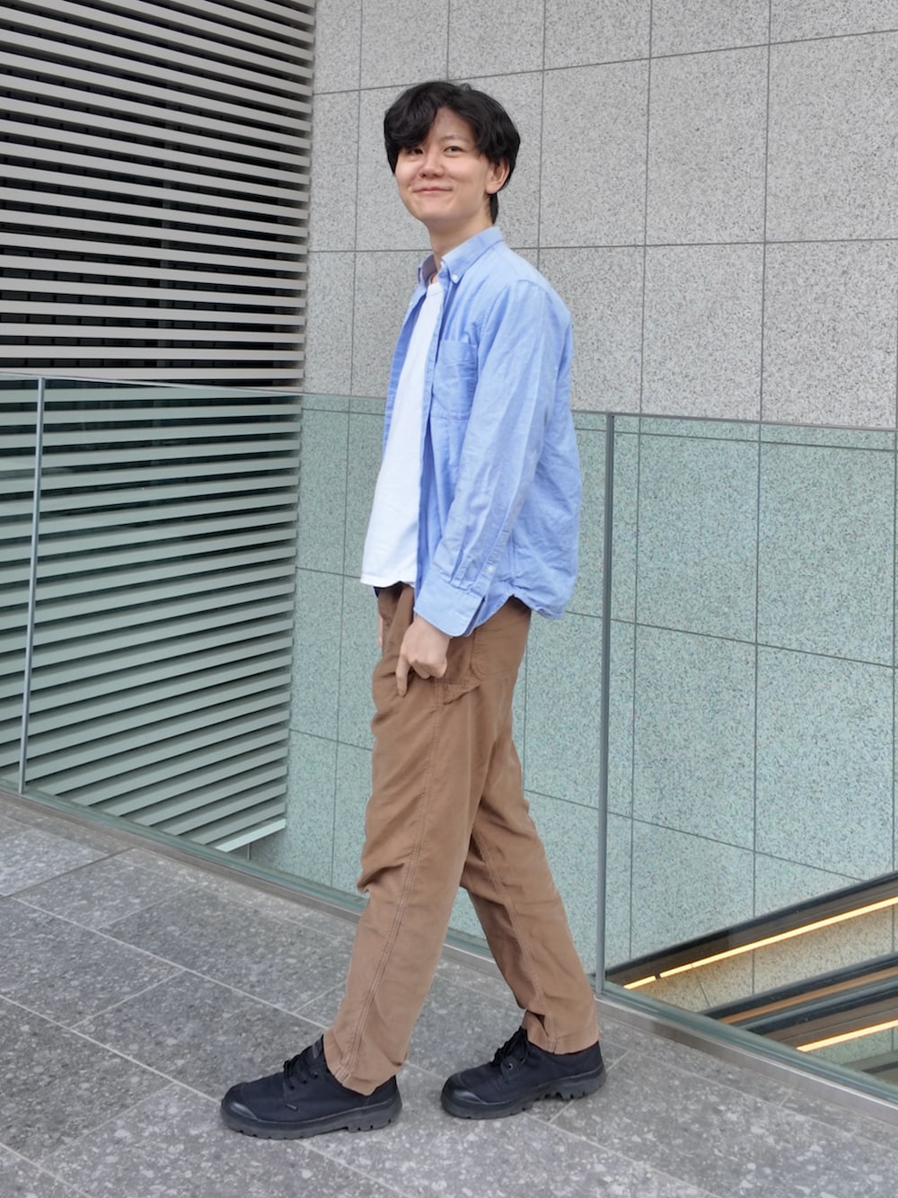 ブルー系のシャツ/ブラウス、ブラウン系のパンツ、ブラック系のスニーカーを着用したメンズの春コーディネートの2枚目の写真