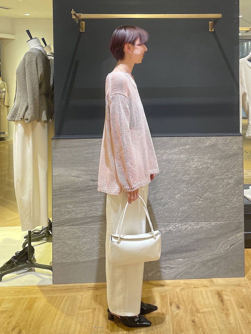 ブラック系のパンプス、ホワイト系のショルダーバッグ、ピンク系のニット/セーターを着用したレディースの春コーディネートの3枚目の写真