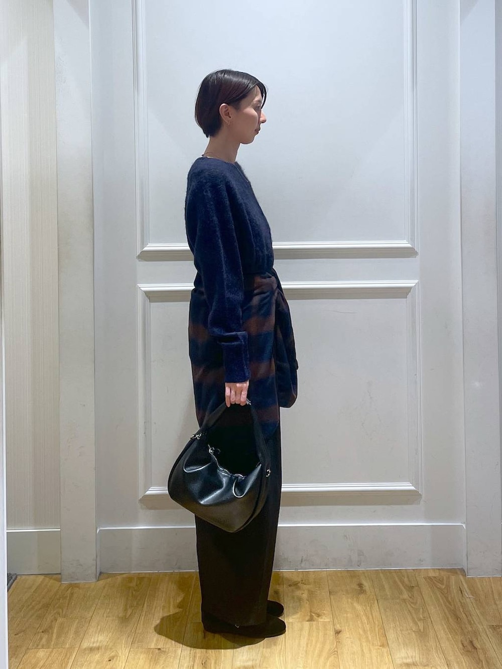 ブラック系のハンドバッグ、ブラック系のスラックス、ブラック系のバレエシューズを着用したレディースの秋コーディネートの3枚目の写真