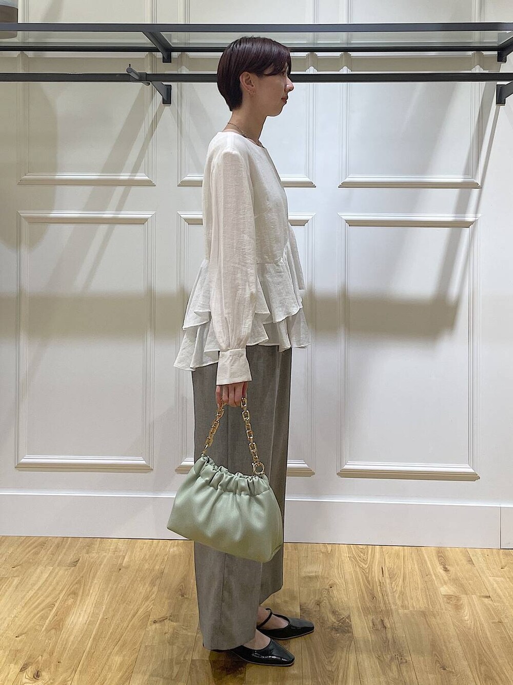 グリーン系のショルダーバッグ、ブラック系のその他パンツ、ホワイト系のシャツ/ブラウスを着用したレディースの春コーディネートの3枚目の写真