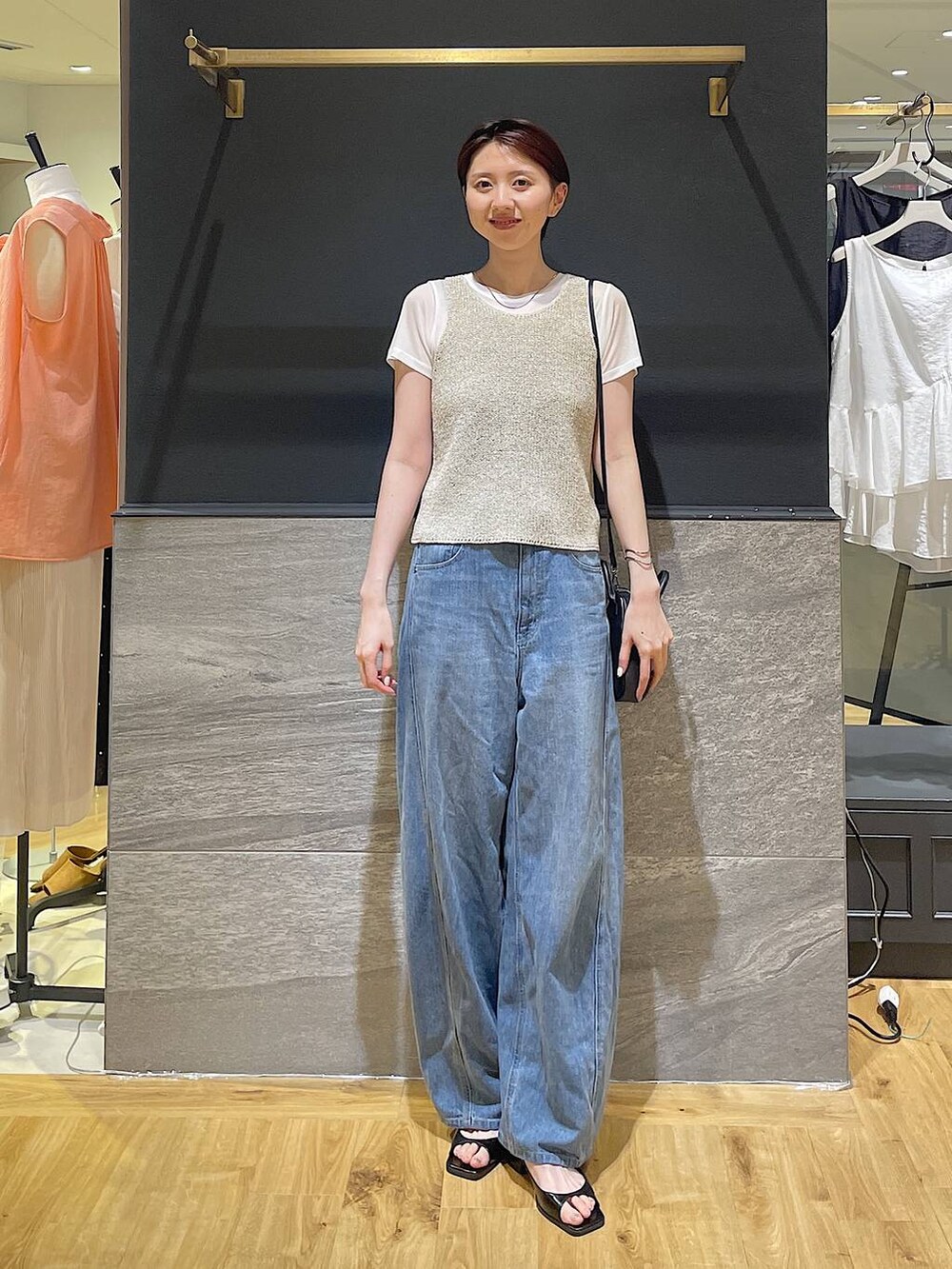 ブルー系のデニムパンツ、ブラック系のパンプス、ベージュ系のニット/セーターを着用したレディースの夏コーディネートの4枚目の写真