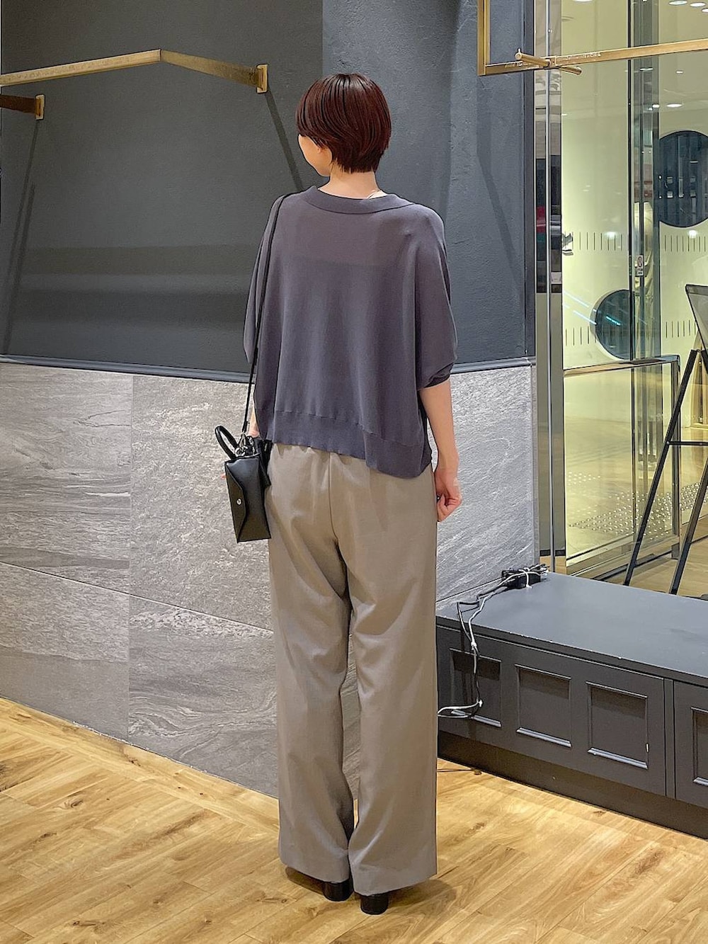 グレー系のニット/セーター、ブラック系のパンプス、ベージュ系のスラックスを着用したレディースの夏コーディネートの4枚目の写真