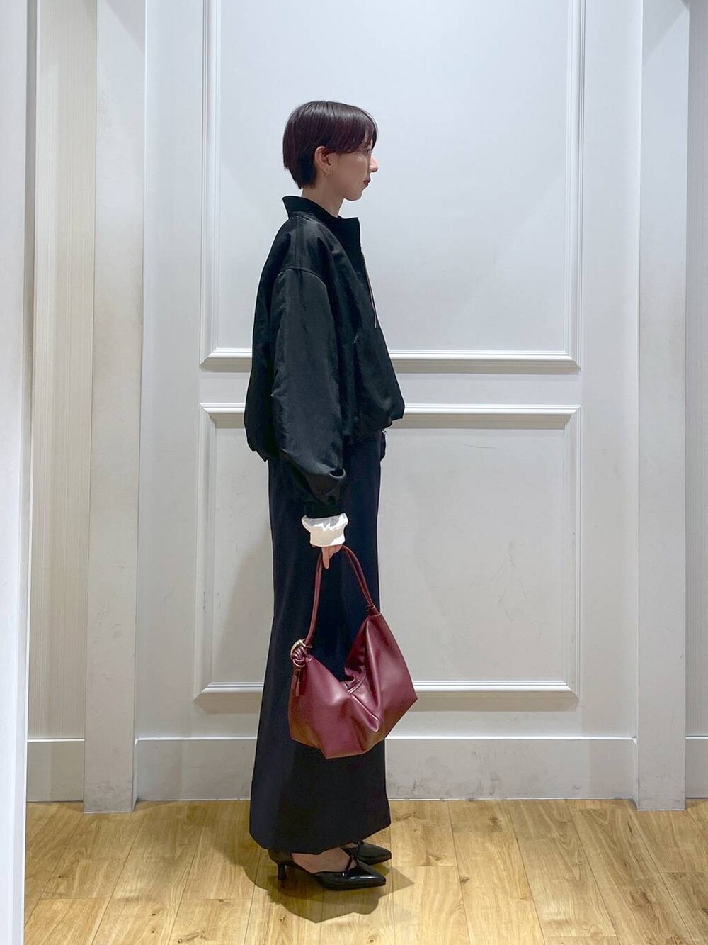 ブラック系のパンプス、ブルー系のスカート、ブラック系のブルゾンを着用したレディースの秋コーディネートの3枚目の写真