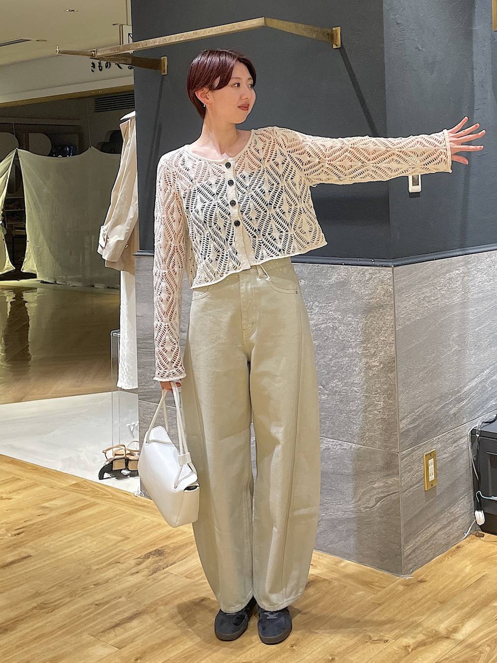 ベージュ系のデニムパンツ、ホワイト系のショルダーバッグ、ホワイト系のカーディガン/ボレロを着用したレディースの春コーディネートの2枚目の写真