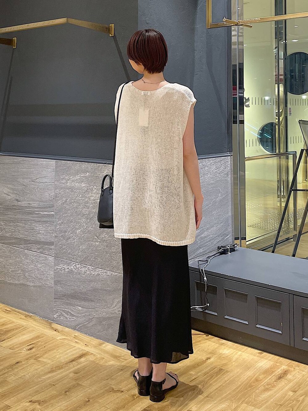 ホワイト系のニット/セーター、ベージュ系のニット/セーター、ブラック系のサンダルを着用したレディースの夏コーディネートの3枚目の写真