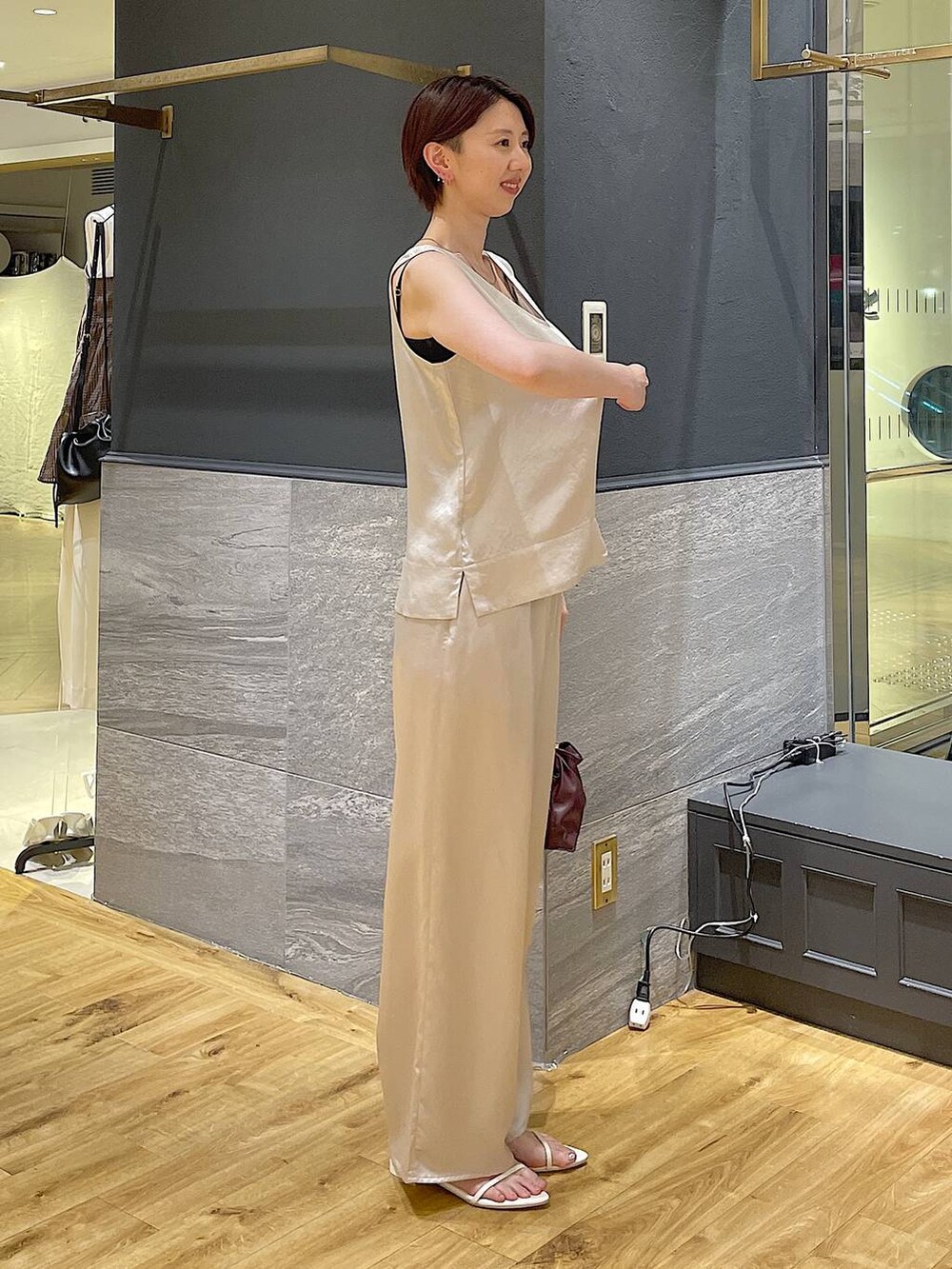 レッド系のショルダーバッグ、ホワイト系のサンダル、ホワイト系のシャツ/ブラウスを着用したレディースの夏コーディネートの2枚目の写真