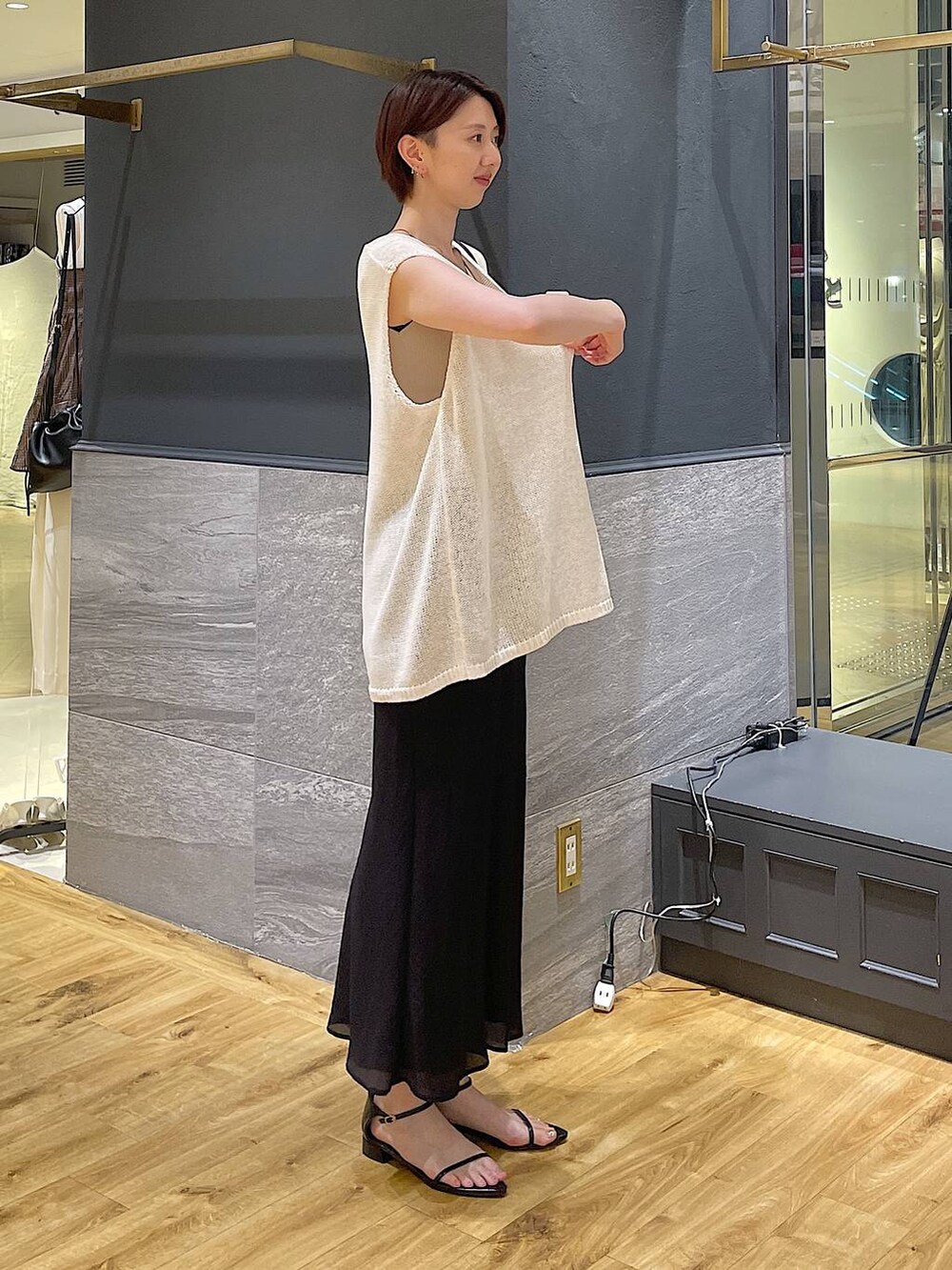 ホワイト系のニット/セーター、ベージュ系のニット/セーター、ブラック系のサンダルを着用したレディースの夏コーディネートの2枚目の写真