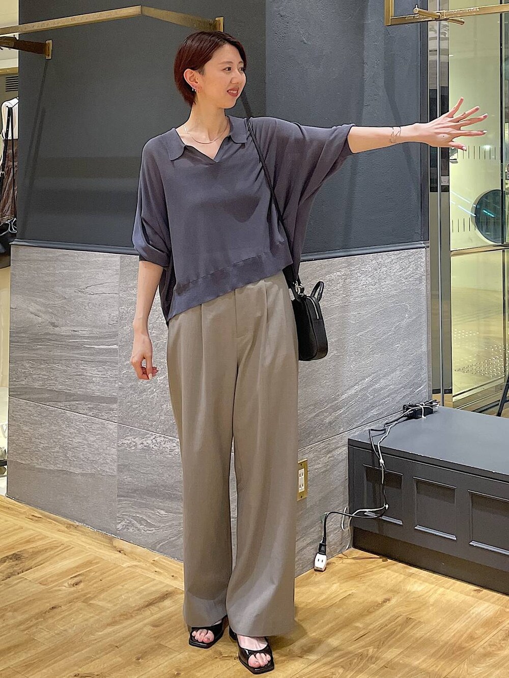 グレー系のニット/セーター、ブラック系のパンプス、ベージュ系のスラックスを着用したレディースの夏コーディネートの2枚目の写真