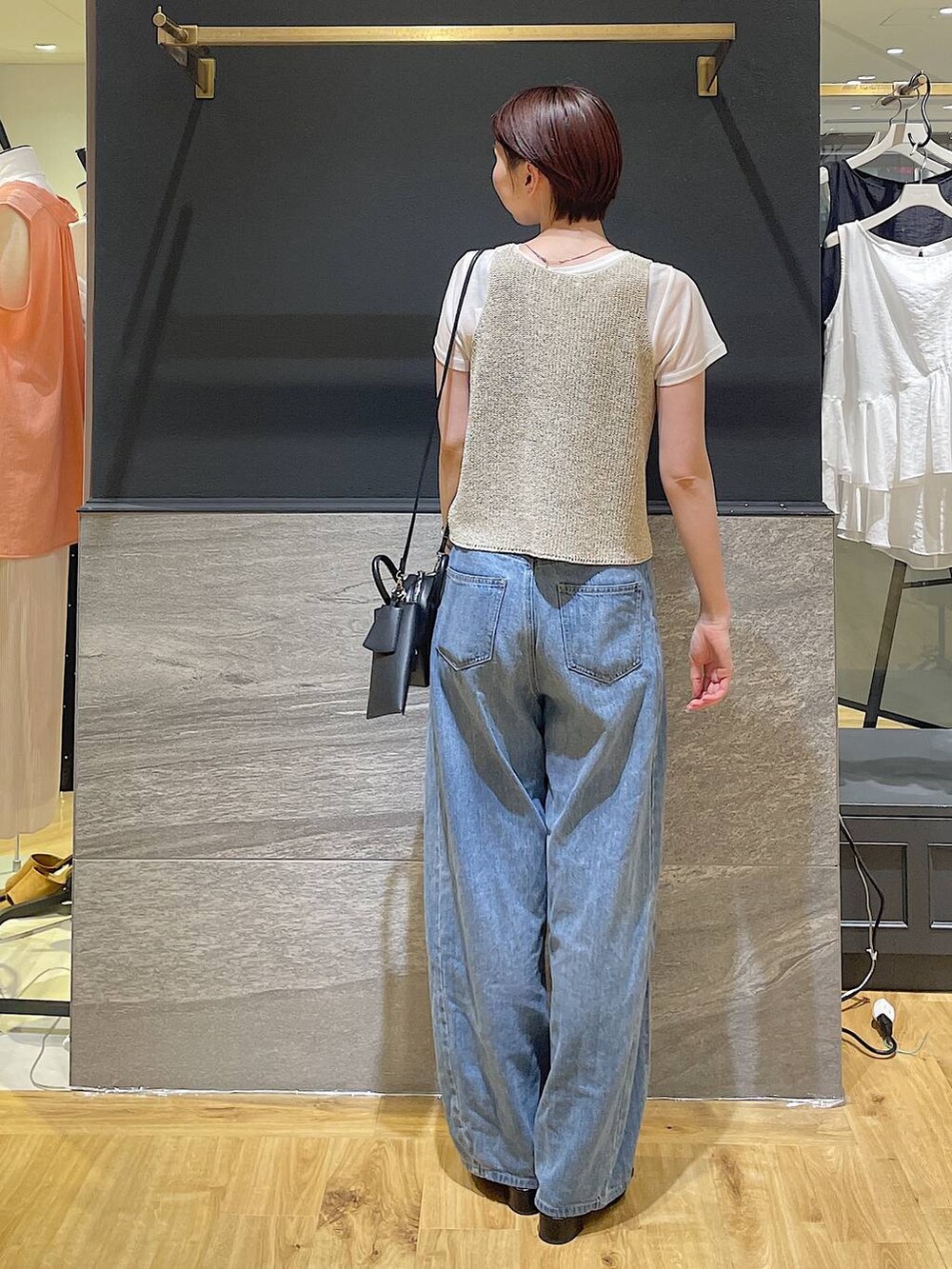 ブルー系のデニムパンツ、ブラック系のパンプス、ベージュ系のニット/セーターを着用したレディースの夏コーディネートの3枚目の写真